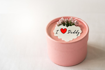 Happy father's day concept. Gift box and flower, paper tag with I Love Daddy text.