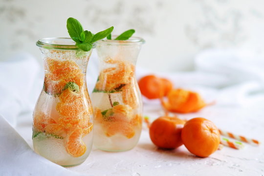Glassware with refreshing citrus mandarine mint fruits cocktail, detox water on white  background