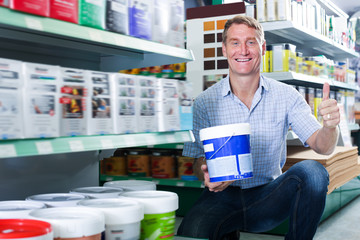 Adult man customer picking paint tin © JackF