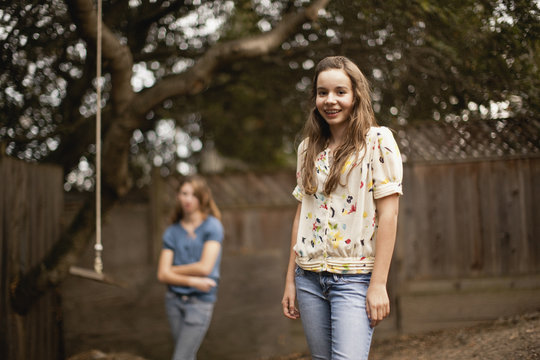 Two teenage girls in a backyard.