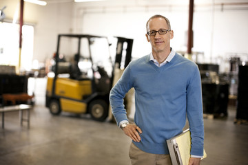 Portrait of a mature man standing in a factory.