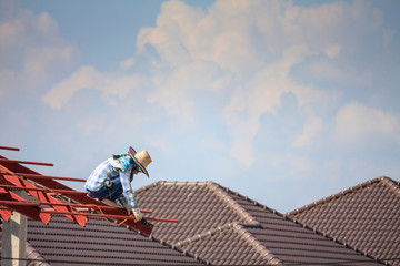 welder workers installing steel frame structure of the house roof at building construction site