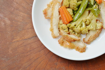 stir fried cauliflower with carrot and garden pea topping chicken on plate