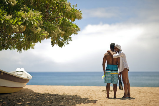Mature woman hugging her husband at the beach. - Powered by Adobe
