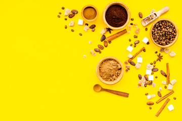 Ingredients for bakery and desserts. Cinnamon, cocoa, coffee, sugar, spices on yellow background top view space for text