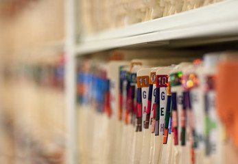 Close-up of folders sorted on the shelf in hospital office.