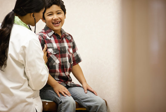 Boy being examined by doctor with stethoscope.