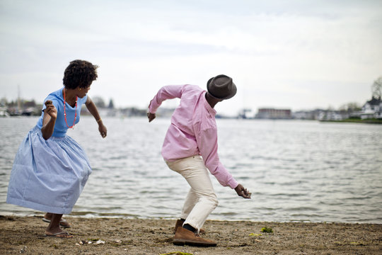 Couple skimming stones by the river