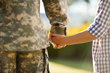 Midsection of father and son holding hands
