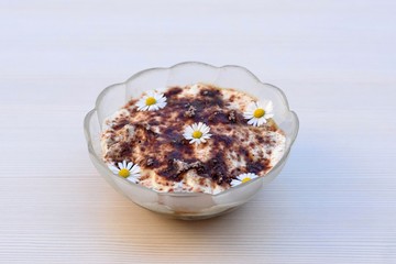Tiramisu dessert in glass bowl, decorated with daisies