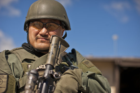 Mid adult military policeman holding a gun.