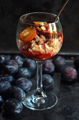 Healthy oatmeal with plums in a glass