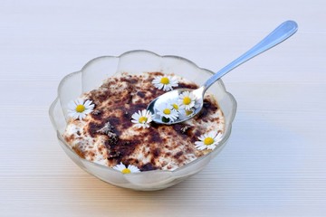 Tiramisu dessert in glass bowl, decorated with daisies flowers