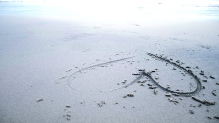 Beautiful heart picture on sand beach background.