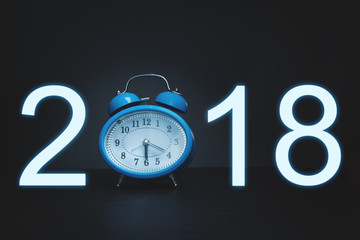 New year 2018 words with blue alarm clock on dark.
