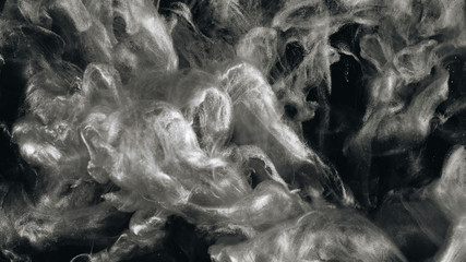 Silver ink in water shooting with high speed camera. Paint dropped, reacting, creating abstract cloud formations and metamorphosis on black. Art backgrounds.