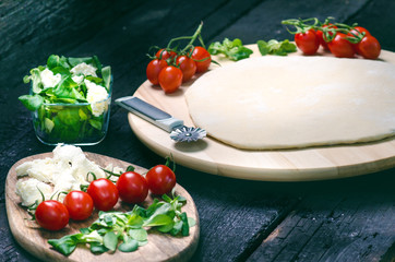 Italian food, cuisine. Margherita pizza on a black, wooden table with igredients like tomatoes, salad, cheese, mozzarella, basil. Delicious homemade food.  - 204406513