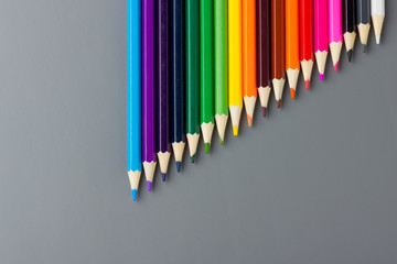 Color pencils on a gray background are descending in length.