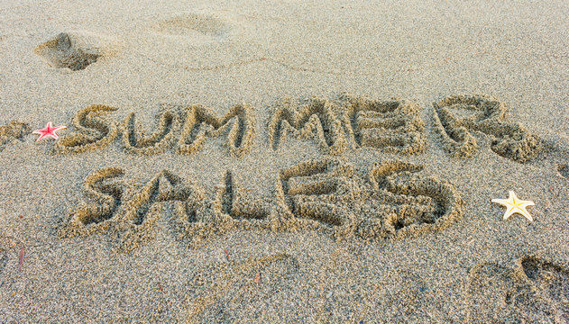 the word summer sales / the word summer sales written on the sand