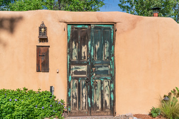 Fototapeta premium adobe wall with blue wooden gate santa fe new mexico