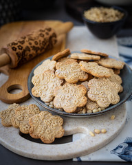 On the plate is a curly cookie with decorative patterns made with a wooden rolling pin