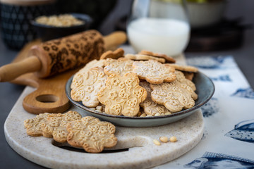 On the plate is a curly cookie with decorative patterns made with a wooden rolling pin
