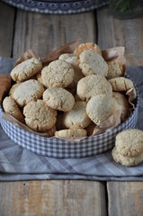 On a wooden table, small round biscuits with sesame seeds. In the gift box