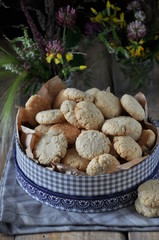 On a wooden table, small round biscuits with sesame seeds. In the gift box