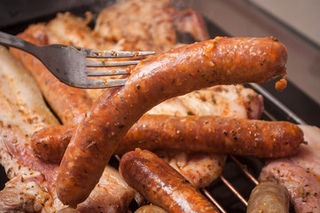 closeup of sausages and pork belly on the barbecue