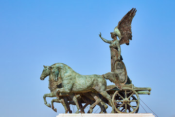 View of National Monument to Victor Emmanuel II showing metal horses and angel against blue sky, Italy.
