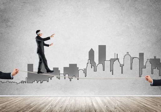 Business concept of risk support and assistance with man balancing on rope