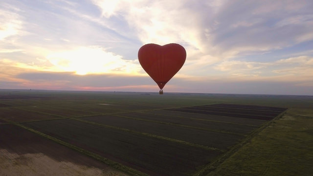 Hot air balloon shape of a heart in the blue sky. Aerostat, Airship. Red balloon.