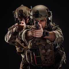 soldiers or private military contractors holding rifle. Image on a black background. war, army, weapon, technology and people concept