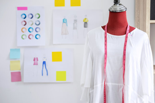 Red dummy in white clothes with measuring tape in tailors studio, Creative Design and Artistic Concept