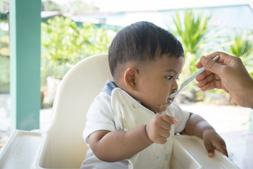 Mom feeding food to baby