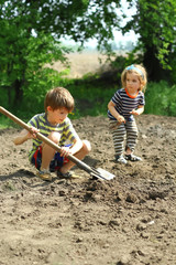 Children helping to plant potatoes in the kitchen garden