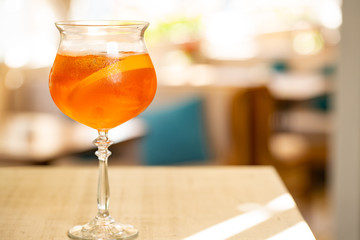 orange cocktail decorated with orange slice and ice