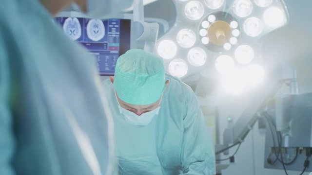 Close-up Shot in the Operating Room, Assistant Hands out Instruments to Surgeons During Operation. Surgeons Perform Operation. Shot on RED EPIC-W 8K.