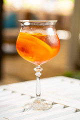 orange cocktail decorated with orange slice and ice
