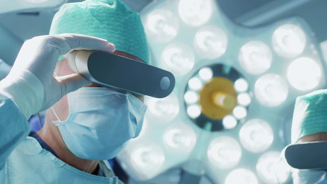 Close-up Shot of a Surgeon Putting on Augmented Reality Glasses to Perform State of the Art Surgery in High Tech Hospital. Shot on RED EPIC-W 8K.