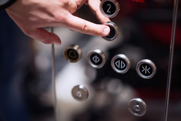 Hand pressing first floor button in the modern elevator. Back to the basics, downshifting,...