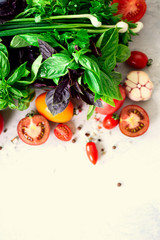 Fresh spinach,green onion, basil, herbs, dill and tomatoes on gray concrete background, selective focus. Top view. Toned effect. Food cooking ingredients. Vegan, raw, detox concept