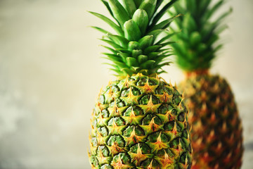 Tropical pineapples on gray background. Summer, holiday concept. Raw, vegan, vegetarian, clean eating diet. Close up of pineapple fruit.