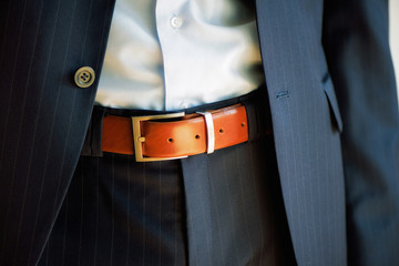 Man wears belt. Young businessman in casual suit with accessories. Fashion and clothing concept....
