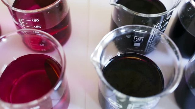 Metal plate of circular shape lying in the potassium permanganate solution, the solution has a different degree of concentration. The forced aging of the metal in a solution of oxidizing chemical. 