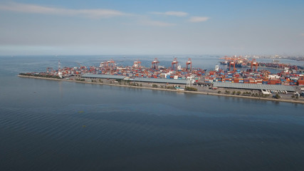 Aerial view industrial cargo port with ships and cranes, Manila. View of the cargo port and container terminal. Container cranes in Manila Bay. Cargo ship in industrial port, Philippines.