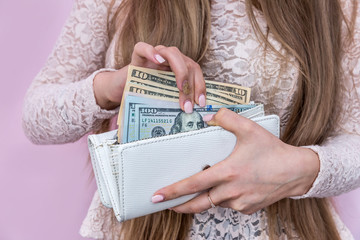 Dollar bills taken off purse by female hands