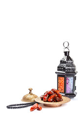 The Muslim feast of the holy month of Ramadan Kareem. Beautiful background with a shining lantern Fanus and dried dates on white. Free space for your text