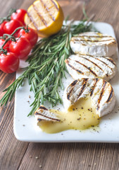 Grilled Camembert cheese with cherry tomatoes and rosemary