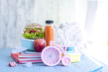School lunch and school notebooks. Pink alarm clock. Place for text. Happy childhood